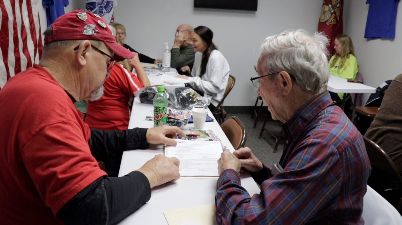 HFSI Volunteer and Veteran review paperwork for upcoming EVV12 flight.